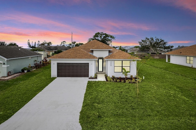 view of front of home featuring a garage and a yard