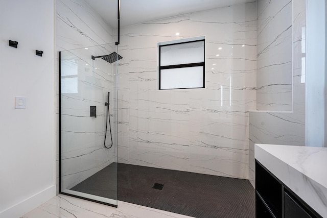 bathroom featuring a tile shower, vanity, and a healthy amount of sunlight