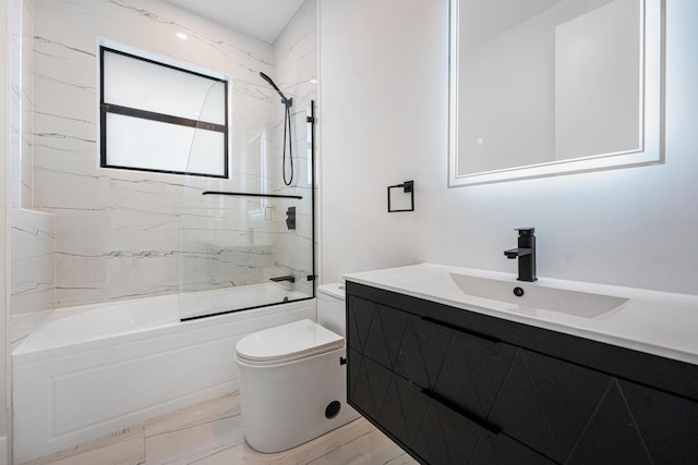 full bathroom with vanity, tiled shower / bath combo, and toilet