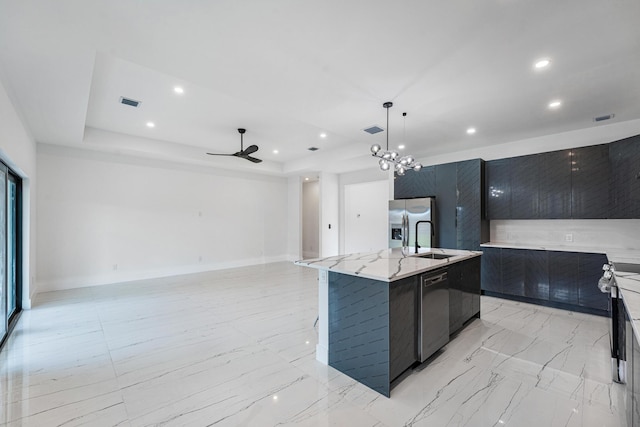 kitchen with appliances with stainless steel finishes, ceiling fan with notable chandelier, a spacious island, sink, and pendant lighting