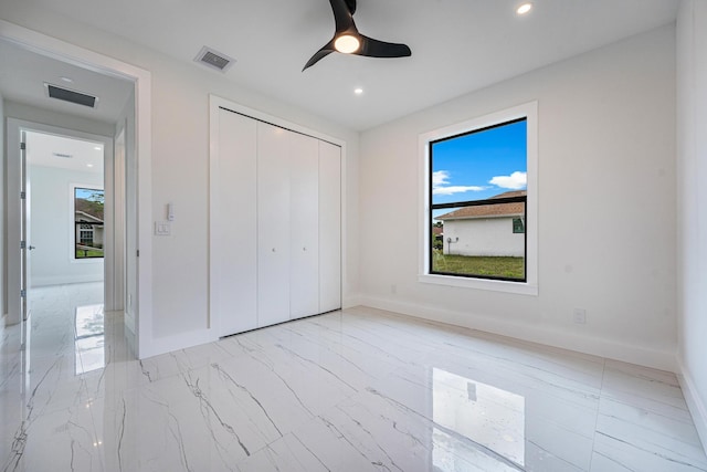 unfurnished bedroom with ceiling fan and a closet