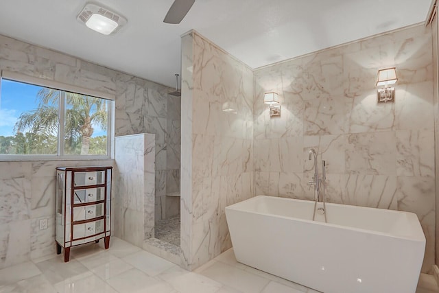 6136 SE Georgetown Pl, Hobe Sound, FL 33455 - bathroom with tile walls, a freestanding bath, a marble finish shower, and marble finish flooring