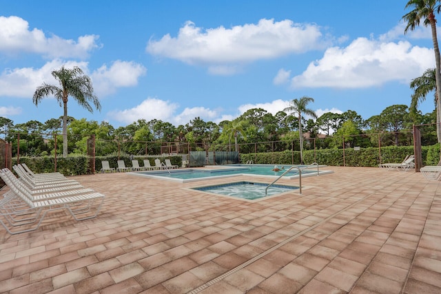 view of pool with a patio and a hot tub