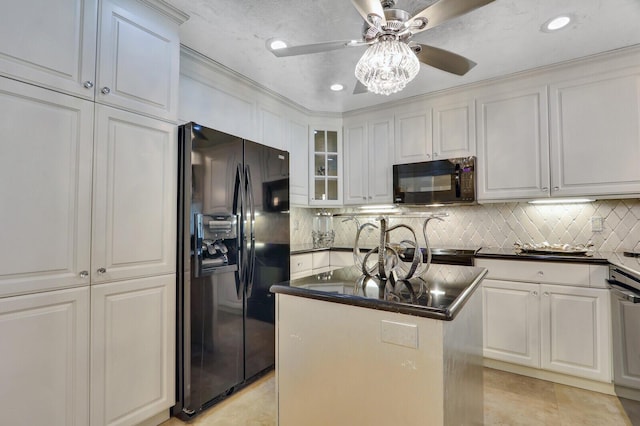 6136 SE Georgetown Pl, Hobe Sound, FL 33455 - kitchen with black appliances, dark countertops, decorative backsplash, a center island with sink, and white cabinetry