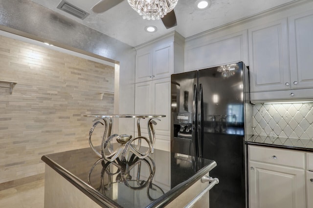 kitchen featuring white cabinets, ceiling fan, black fridge, and backsplash