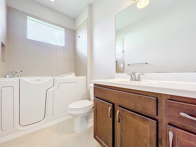 bathroom featuring tile patterned flooring, vanity, toilet, and a tub