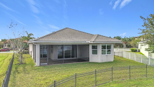 rear view of house with a sunroom and a yard