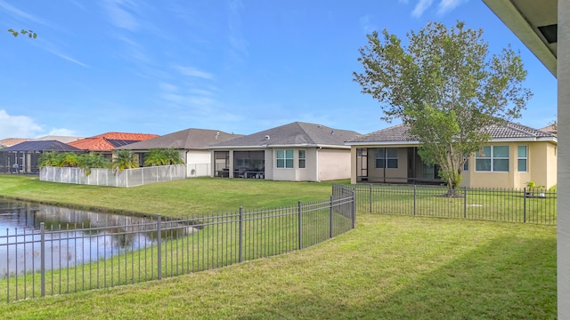 view of yard featuring a sunroom and a water view