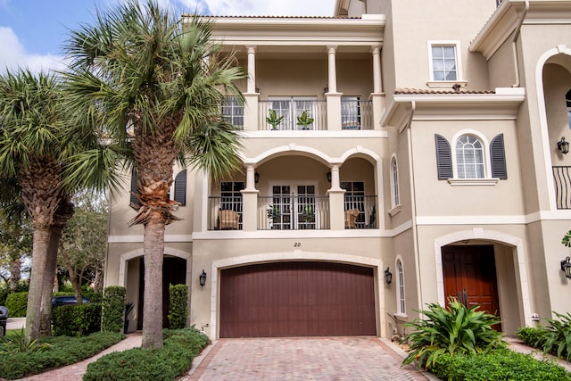 mediterranean / spanish home featuring a balcony and a garage