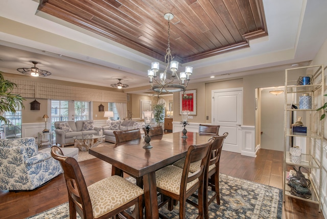 dining room with ceiling fan with notable chandelier, ornamental molding, a tray ceiling, dark hardwood / wood-style flooring, and wood ceiling