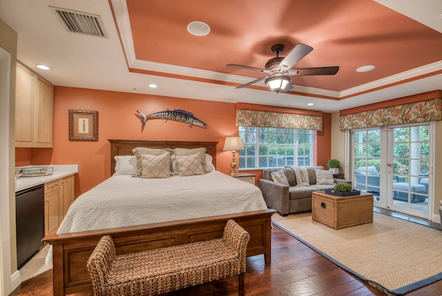 bedroom featuring access to exterior, ceiling fan, black fridge, dark hardwood / wood-style floors, and a tray ceiling