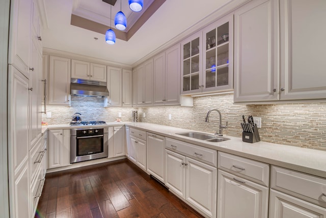 kitchen featuring sink, appliances with stainless steel finishes, decorative light fixtures, dark hardwood / wood-style flooring, and white cabinetry