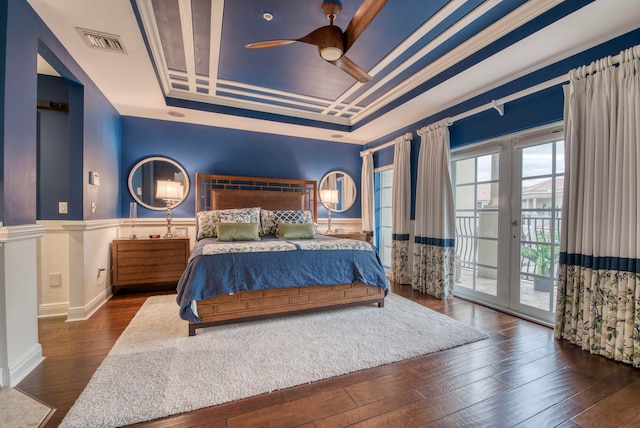 bedroom featuring access to exterior, dark hardwood / wood-style floors, ceiling fan, and a raised ceiling