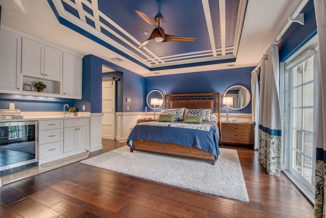 bedroom featuring a tray ceiling, ceiling fan, beverage cooler, and dark hardwood / wood-style floors