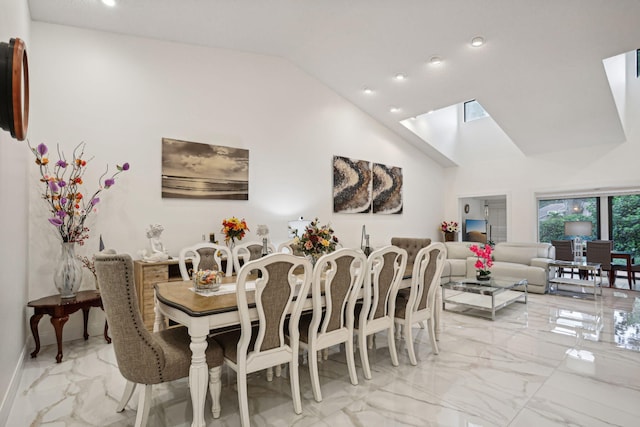 dining area featuring high vaulted ceiling