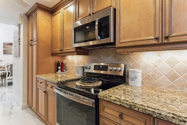 kitchen featuring decorative backsplash, light stone countertops, and stainless steel appliances