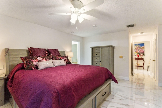 bedroom featuring ceiling fan and a textured ceiling