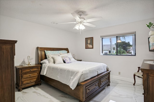 bedroom with ceiling fan and a textured ceiling