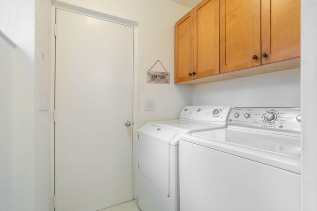 washroom with cabinets and washing machine and dryer