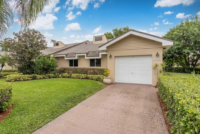 ranch-style house featuring a garage and a front lawn