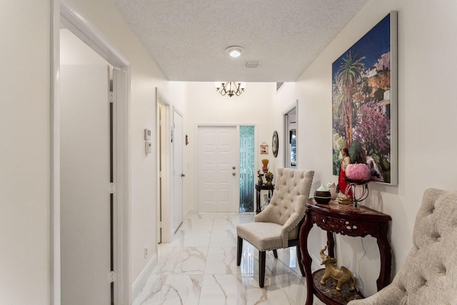 corridor featuring a textured ceiling and a notable chandelier