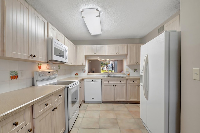 kitchen featuring sink, tasteful backsplash, a textured ceiling, white appliances, and light tile patterned flooring