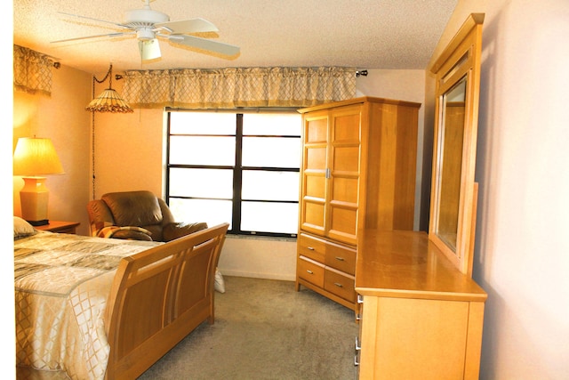 bedroom featuring ceiling fan, carpet floors, and a textured ceiling