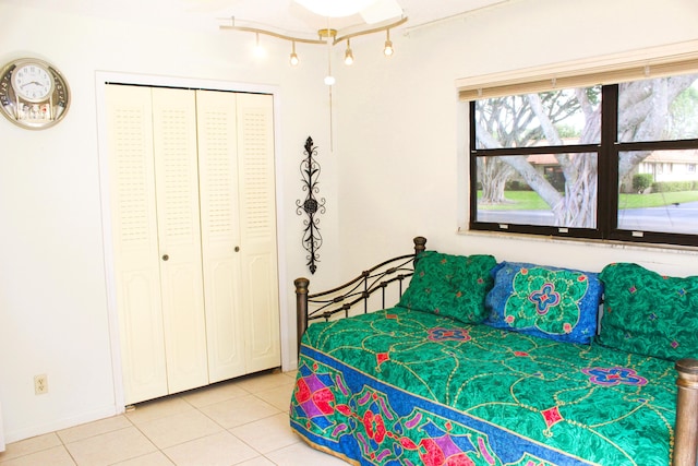 bedroom with light tile patterned floors and a closet