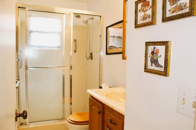 bathroom with vanity, a shower with shower door, and toilet