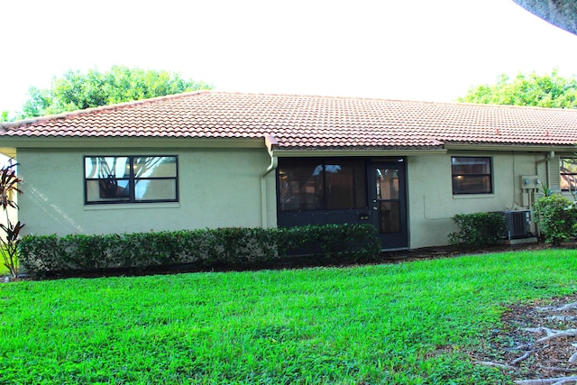 rear view of house featuring a yard and central AC