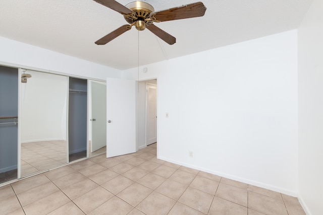 unfurnished bedroom featuring ceiling fan, a closet, and light tile patterned flooring