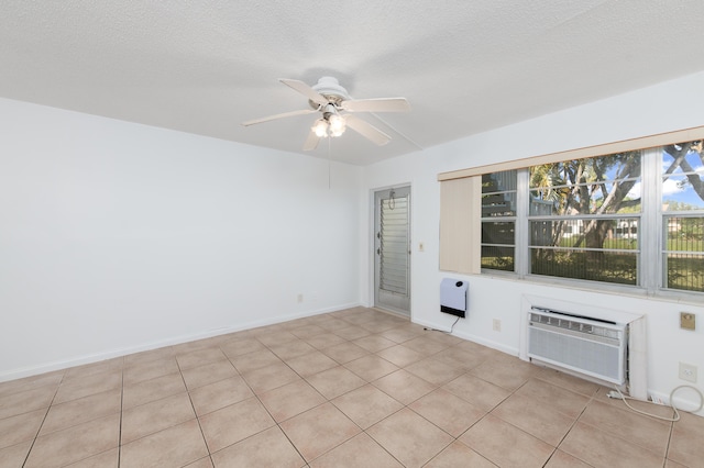 unfurnished room with heating unit, an AC wall unit, light tile patterned floors, ceiling fan, and a textured ceiling