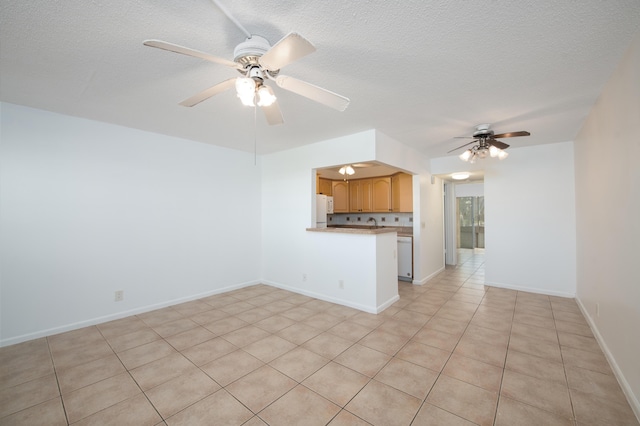 unfurnished living room with a textured ceiling, ceiling fan, and light tile patterned flooring