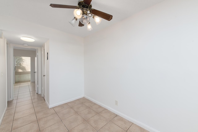 spare room with ceiling fan and light tile patterned floors