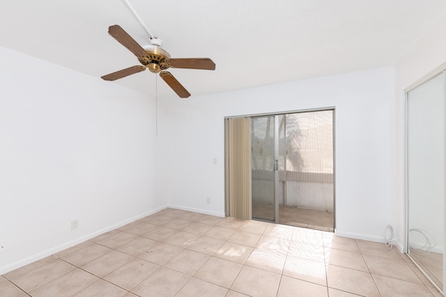 spare room with ceiling fan and light tile patterned floors