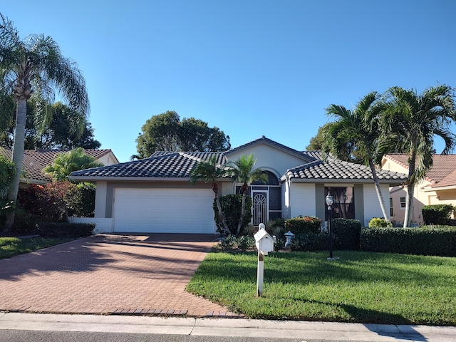 mediterranean / spanish home with a front yard and a garage