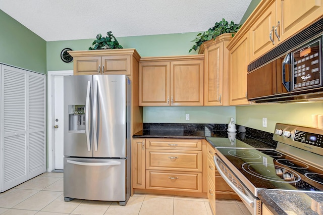 kitchen with light tile patterned flooring, a textured ceiling, and appliances with stainless steel finishes