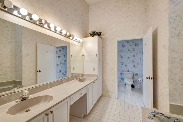 bathroom with tile patterned floors, vanity, toilet, and a tub