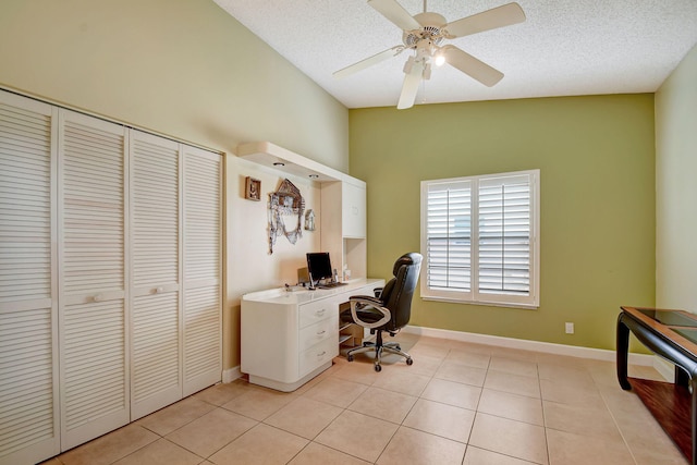 office featuring ceiling fan, light tile patterned flooring, a textured ceiling, and vaulted ceiling