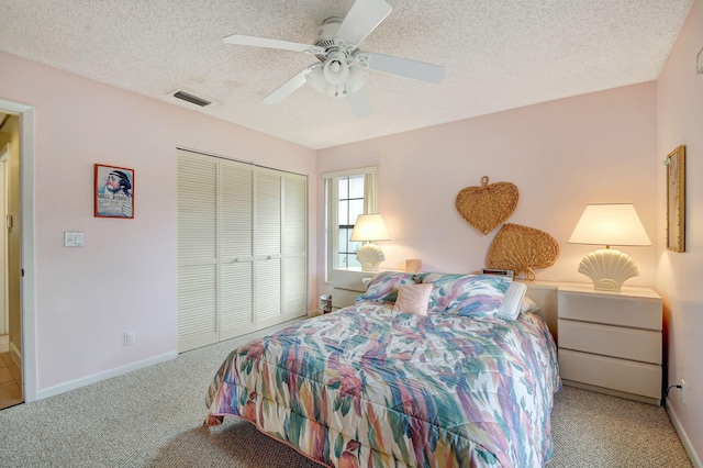 bedroom featuring carpet flooring, a textured ceiling, a closet, and ceiling fan