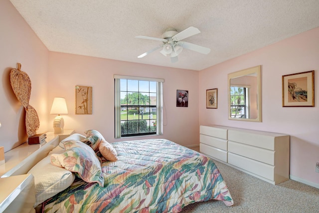 carpeted bedroom featuring a textured ceiling and ceiling fan