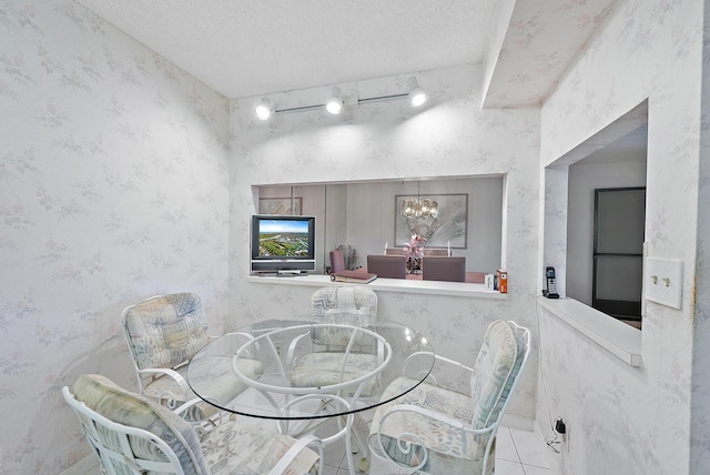 dining space with light tile patterned floors, a textured ceiling, and an inviting chandelier