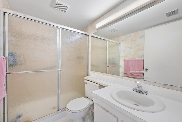 bathroom with vanity, toilet, and a shower with shower door