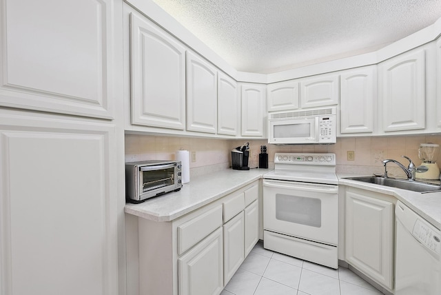 kitchen featuring sink, white cabinets, and white appliances