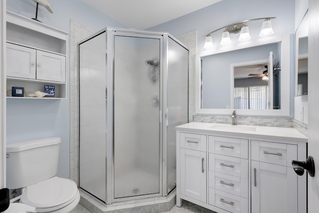 bathroom with ceiling fan, toilet, decorative backsplash, a shower with door, and vanity