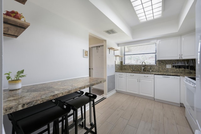 kitchen with white cabinets, white appliances, light hardwood / wood-style floors, and sink