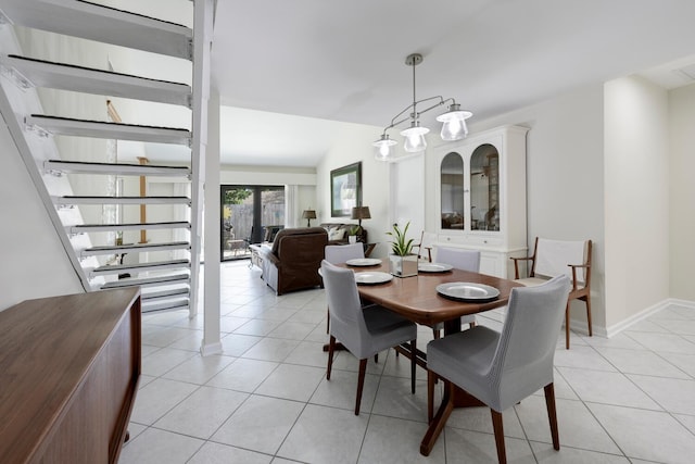 dining space featuring light tile patterned floors and vaulted ceiling