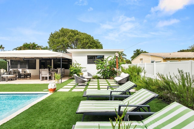 back of house with a fenced in pool, a patio area, and a yard