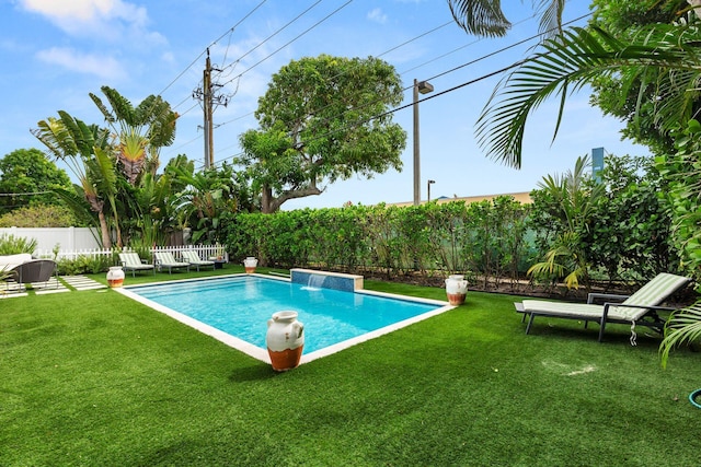 view of pool with a yard and pool water feature