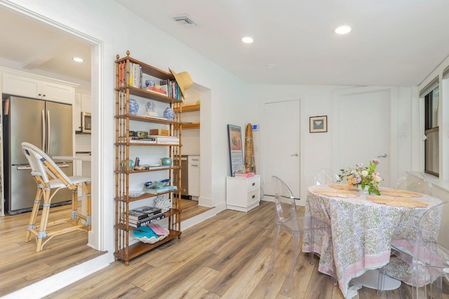 dining space featuring light hardwood / wood-style flooring and vaulted ceiling